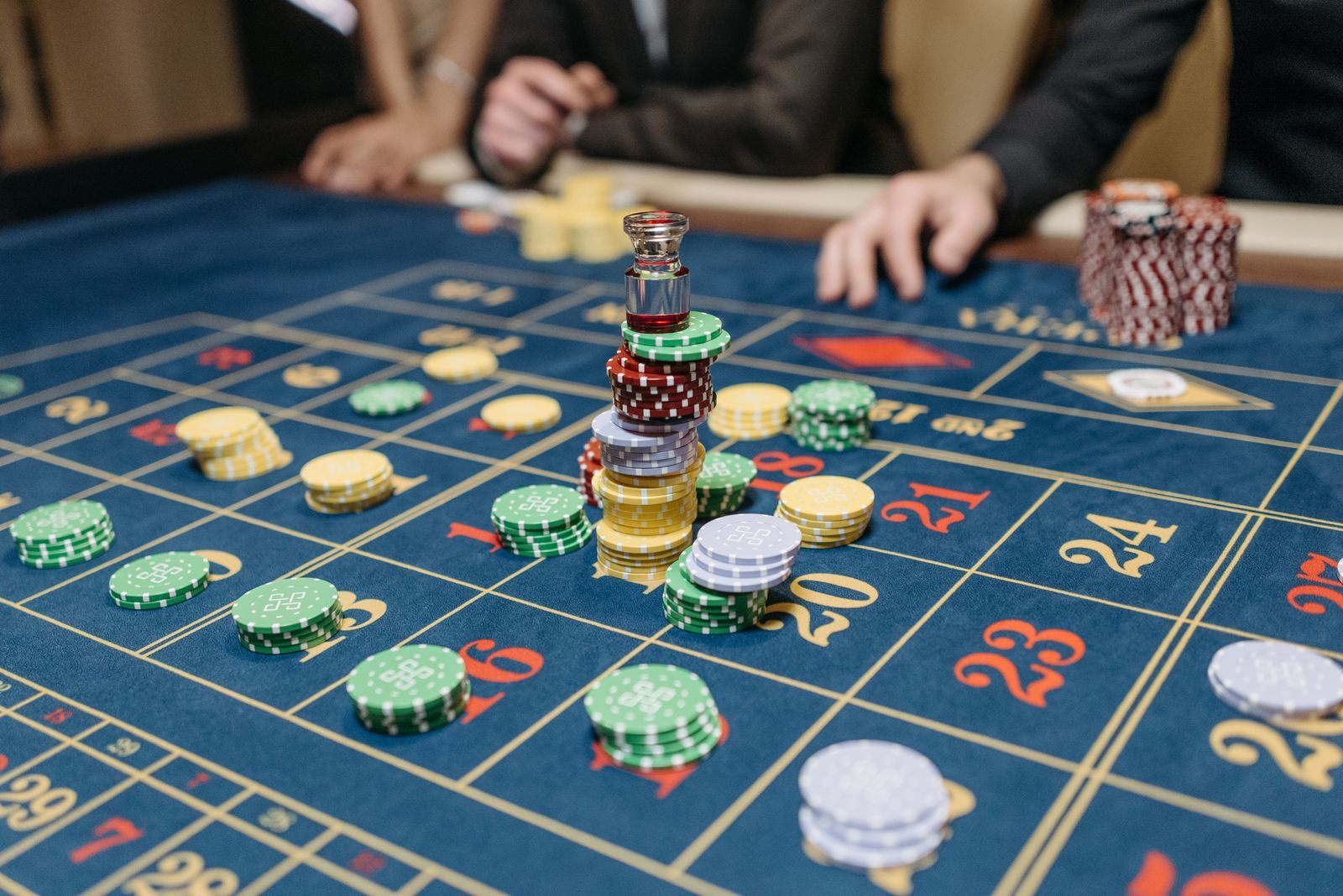 Stacks of colored chips on a blue roulette layout, the play behind casino cruise rewards