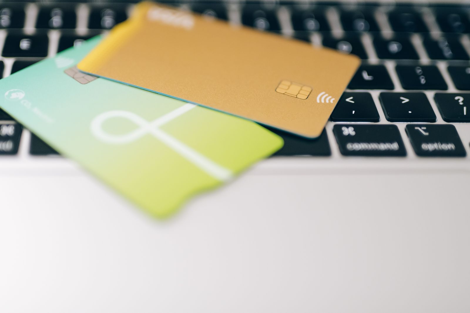 Two payment cards resting on a laptop keyboard, ready to book a cruise with points