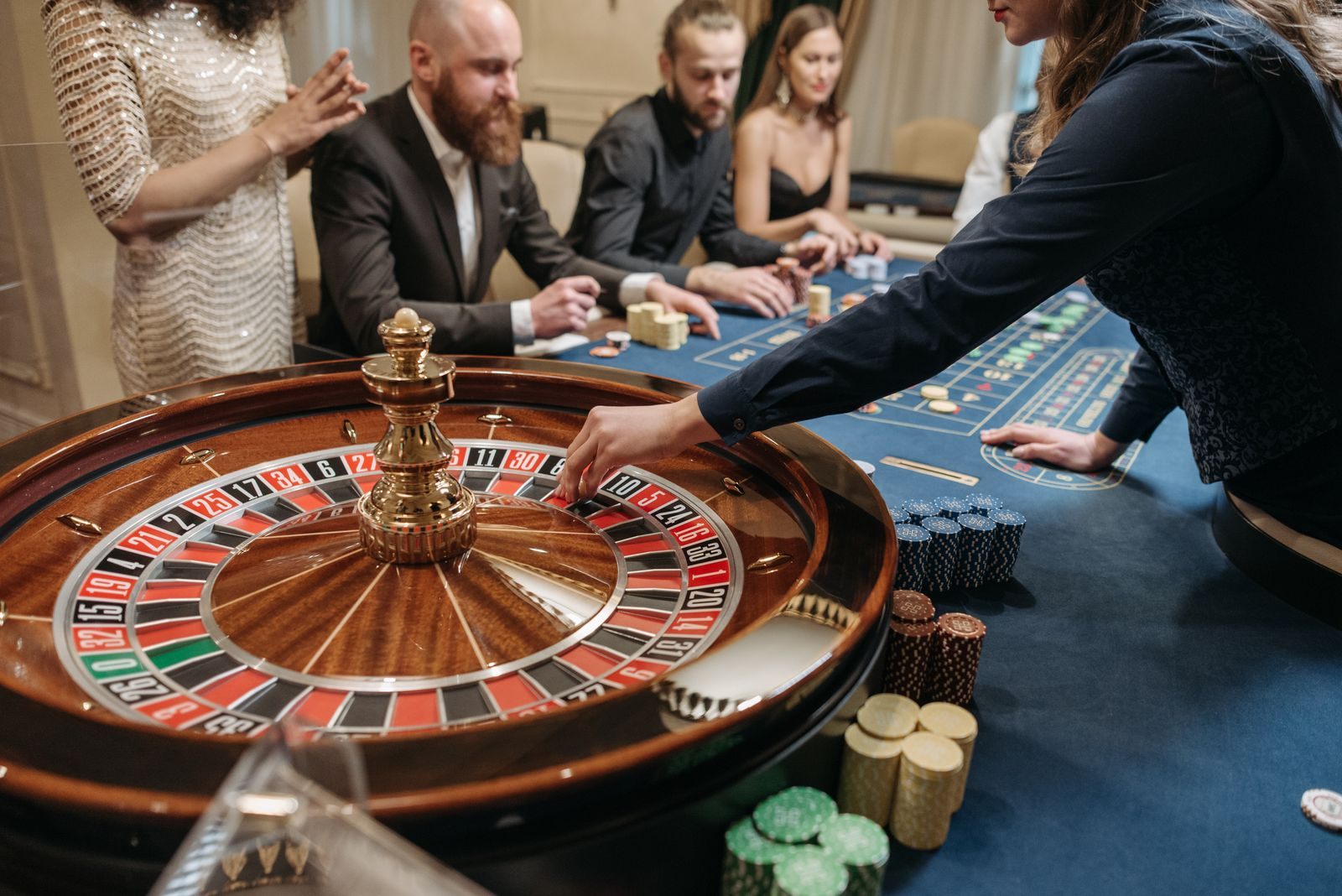 A croupier spins a roulette wheel as players in evening wear watch, the kind of play Club Royale tracks